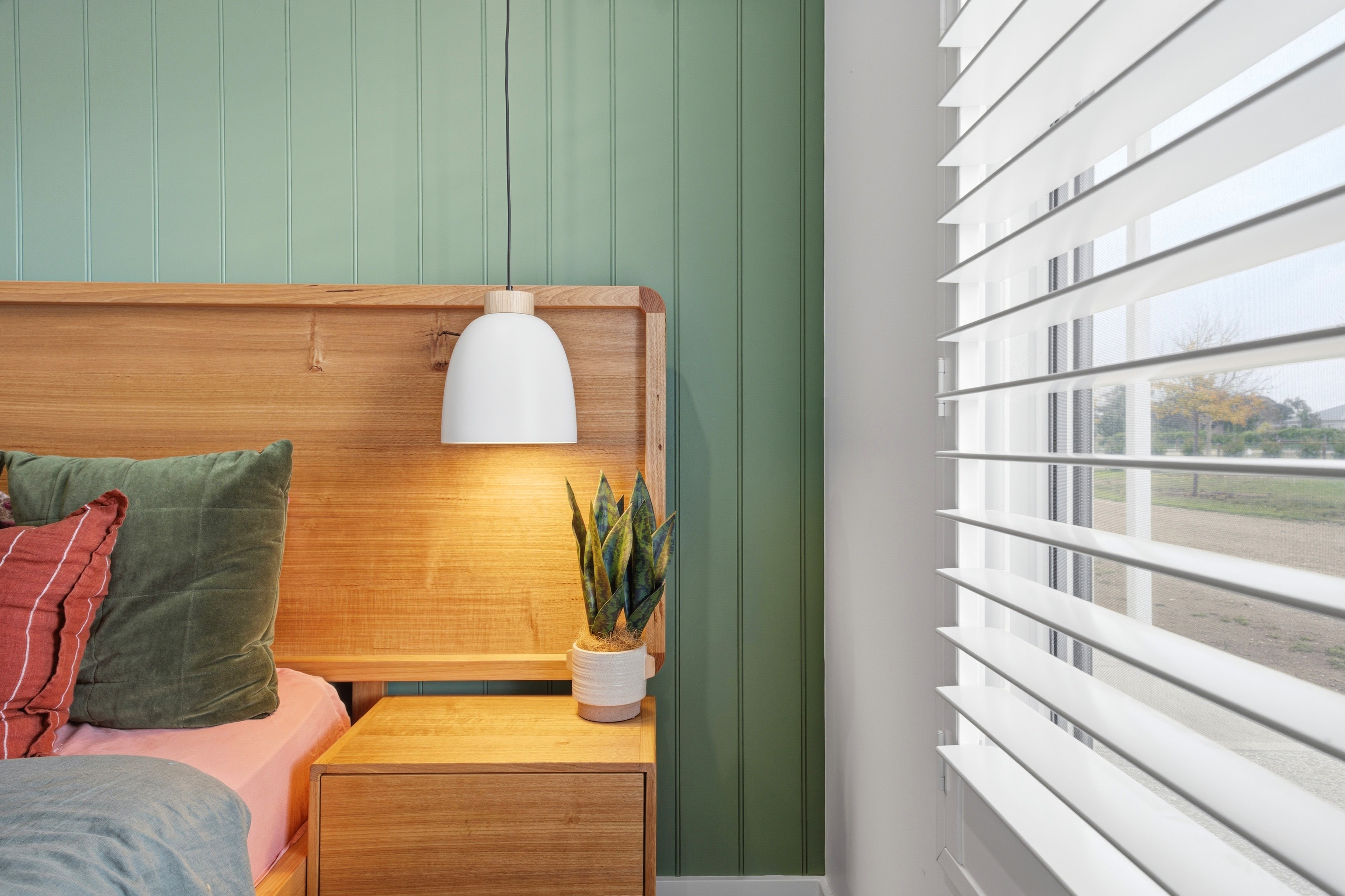Bedside detail with timber headboard and pendant lighting