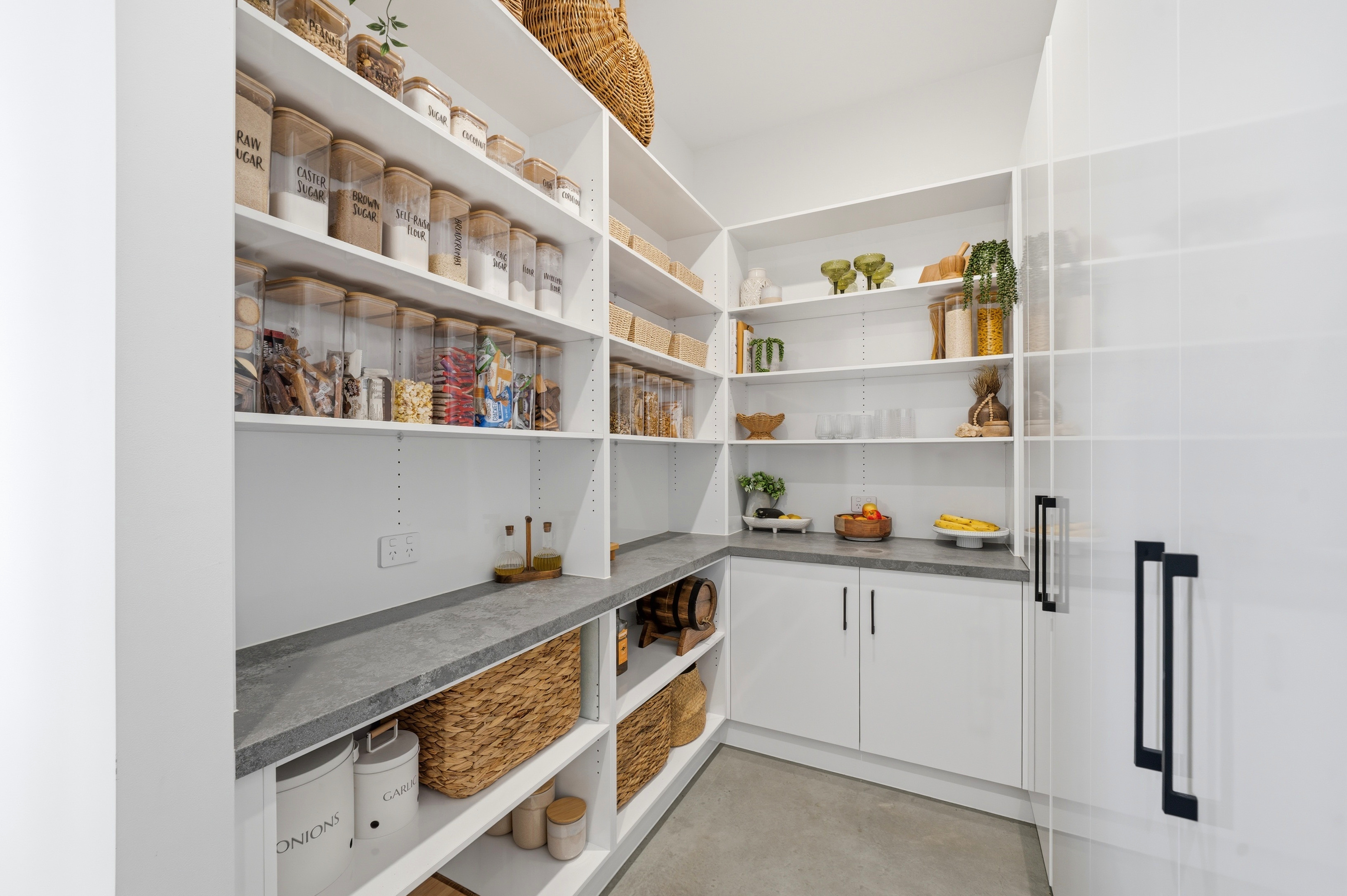 Walk-in butler's pantry with open shelving and stone benchtops