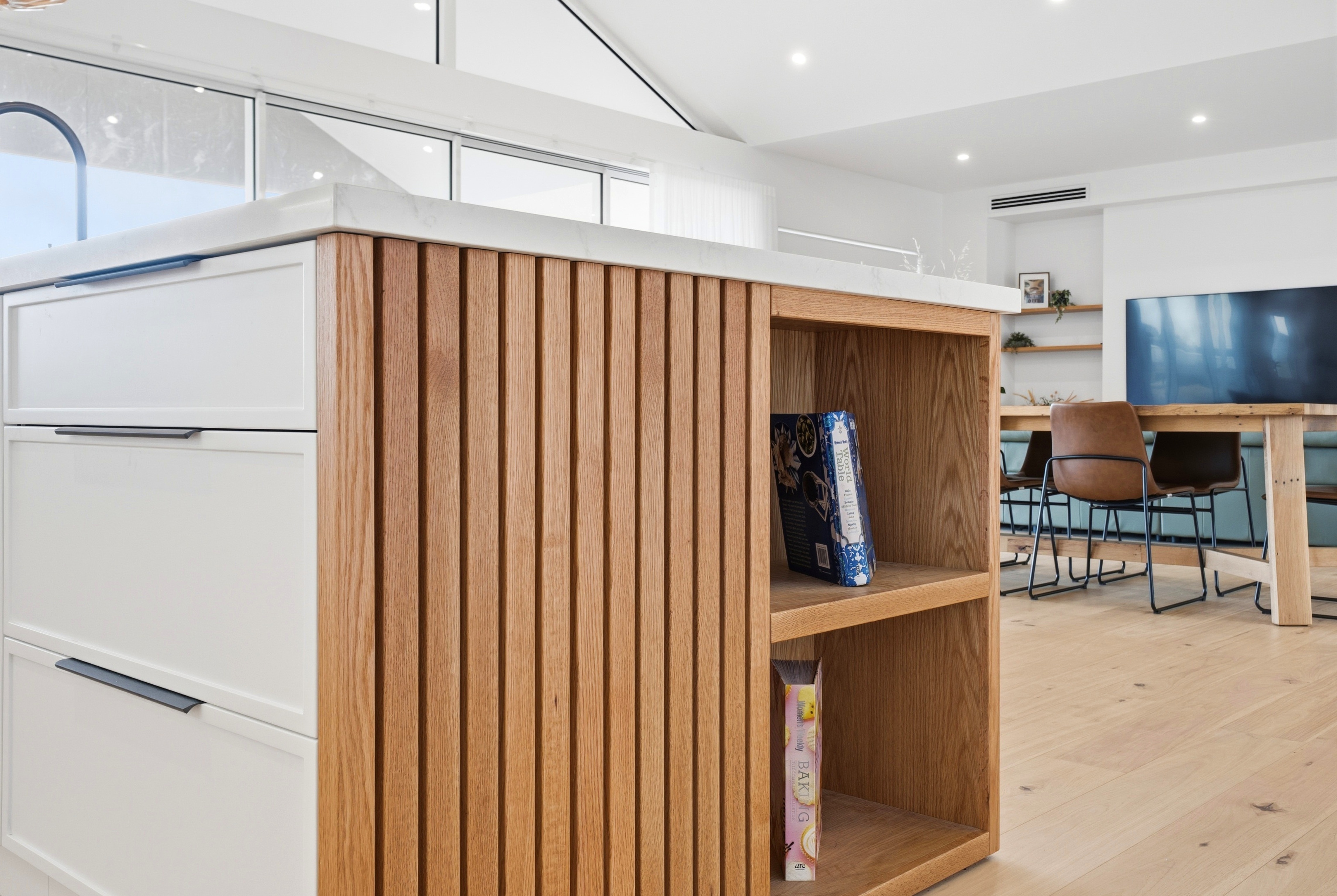 Fluted oak island with built-in display shelving