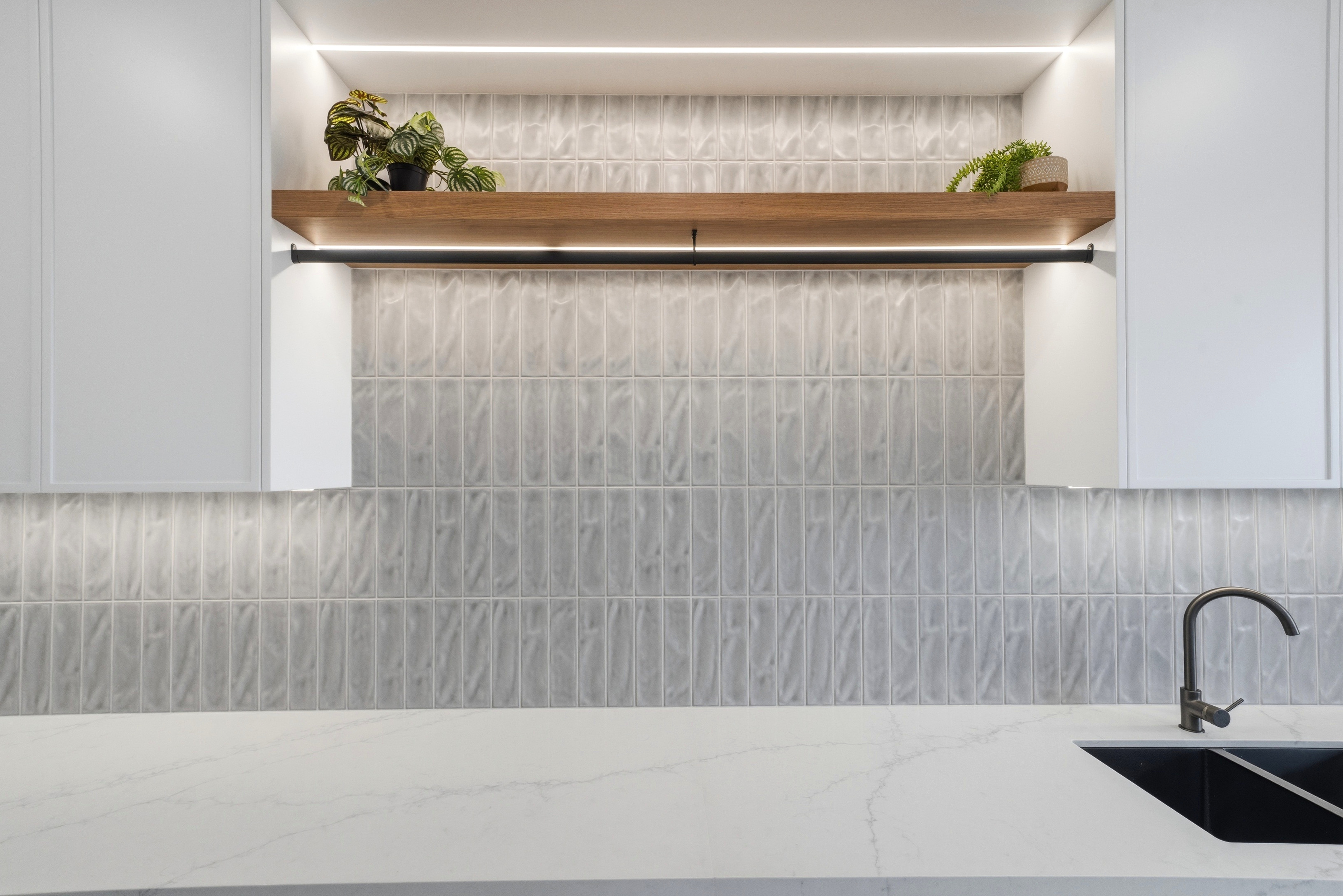 Textured tile splashback with floating oak shelf